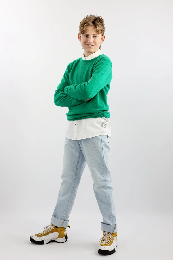 Ganzkörperfoto eines Jungen im grünnen Pulover.
