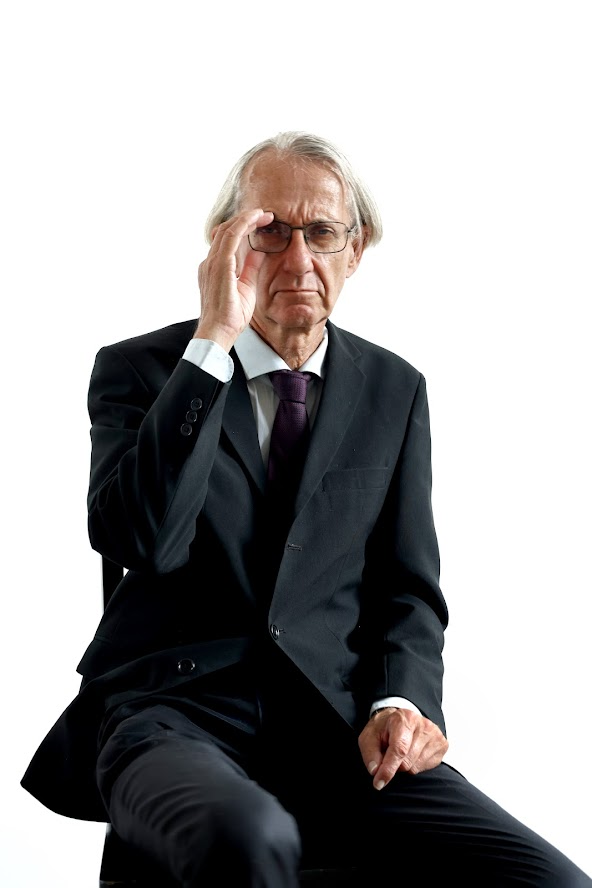 Halbkörper-Porträtfoto eines Schauspielers – älterer Mann mit Brille, schwarzer Anzug mit Krawatte, Fotostudio Bern